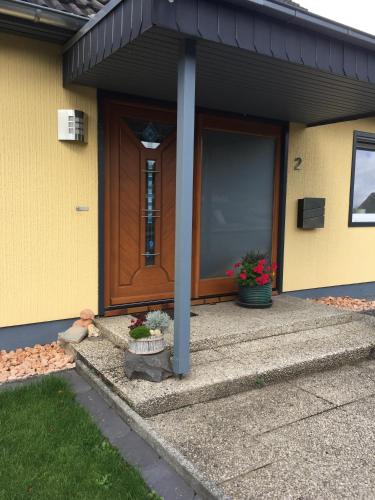 a front door of a house with flowers in front of it at FEWO Schmandin Laacher See in Wassenach