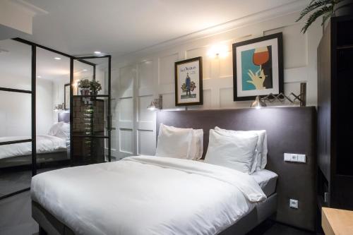 - une chambre avec un grand lit blanc et un miroir dans l'établissement The Highland House, à Amsterdam