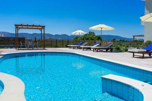 a swimming pool with two chairs and an umbrella at Villa Kampos in Vanáton
