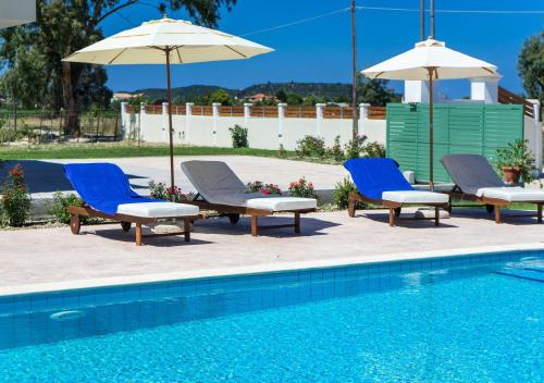a group of chairs and umbrellas next to a pool at Villa Kampos in Vanáton