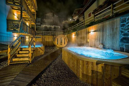 a large wooden bath tub in a room with stairs at Chalet Marcora in Campitello di Fassa