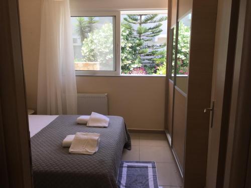 Agios OnoufriosにあるPretty Apartmentのベッドルーム1室(ベッド1台、タオル2枚付)