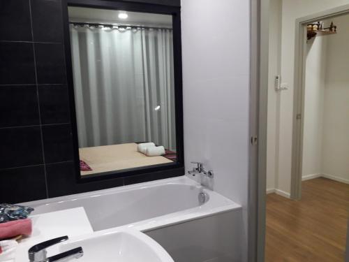 a bathroom with a tub and a sink and a mirror at New Loft Modern Home in Hang Dong