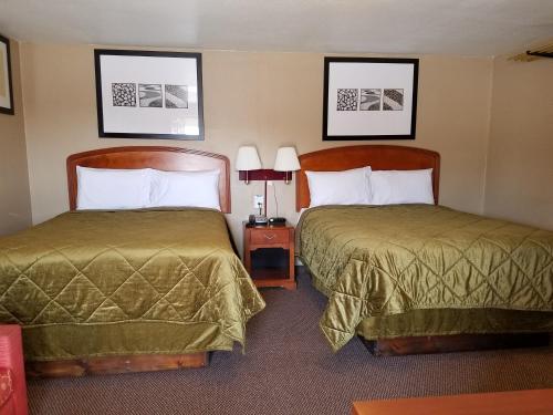 Habitación de hotel con 2 camas y 2 lámparas en Budget Inn, en Chickasha