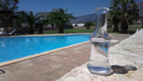 a bottle sitting on a wall next to a swimming pool at Kallicrates Village in Frangokastello
