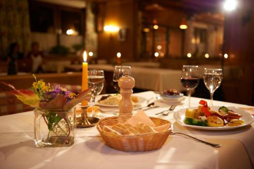 a table with plates of food and glasses of wine at Blasiwirt in Sankt Michael im Lungau