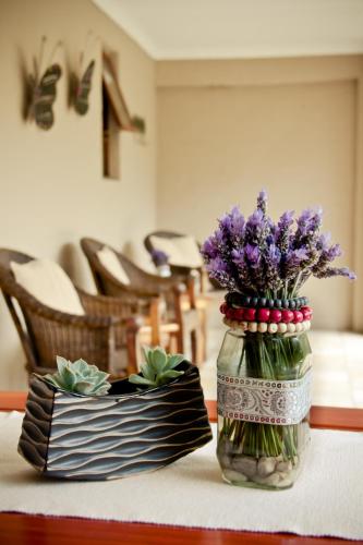 a glass jar filled with purple flowers on a table at De Old Drift Guest Farm in Addo