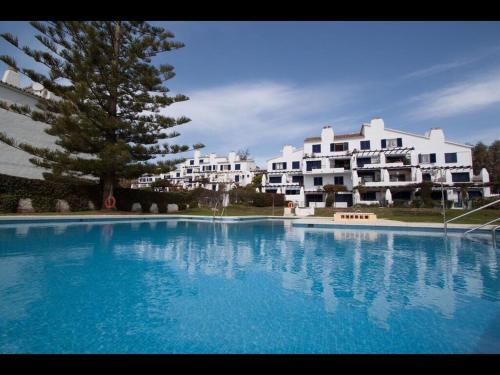 una gran piscina azul frente a un edificio en apartment by the beach, en Mijas Costa