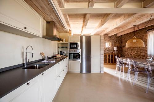 eine Küche mit weißen Schränken und einer Arbeitsplatte in der Unterkunft La Codina in San Bartolomé del Grau