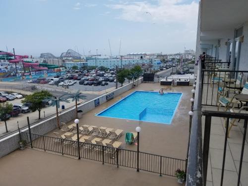 a swimming pool on the balcony of a building with a parking lot at Beach Terrace Motor Inn in Wildwood