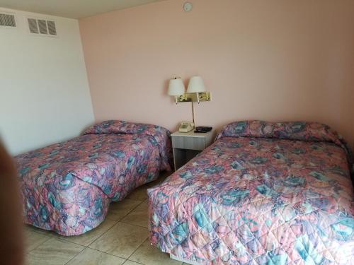 a hotel room with two beds and a table with a lamp at Beach Terrace Motor Inn in Wildwood