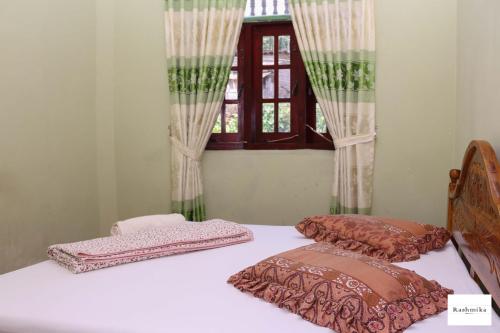 מיטה או מיטות בחדר ב-Rashmika Home Stay