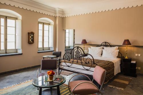 ein Schlafzimmer mit einem Bett, Stühlen und einem Tisch in der Unterkunft Hotel L'Iglesia in El Jadida