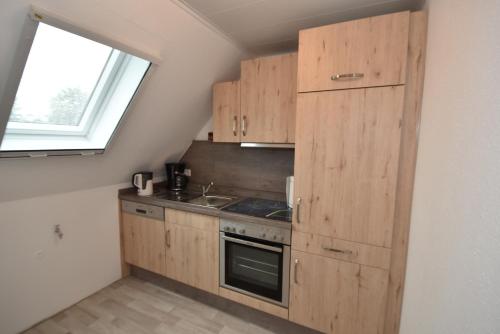 グレートジールにあるAppartement Lilaのキッチン(木製キャビネット、シンク、窓付)