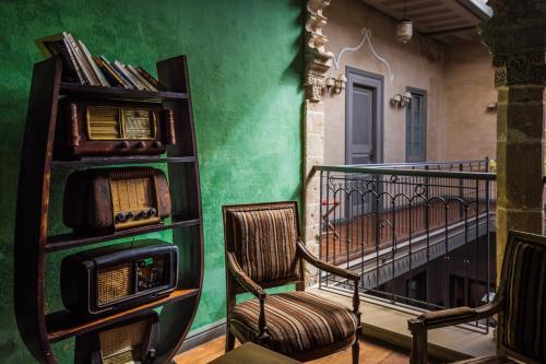 a balcony with two chairs and a book shelf at Hotel L'Iglesia in El Jadida