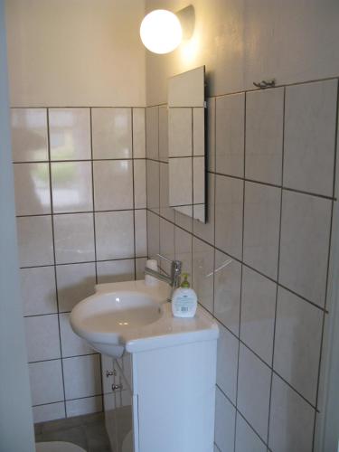 a white bathroom with a sink and a mirror at Motel Europa in Svenstrup