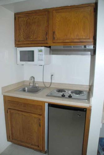 una pequeña cocina con fregadero y microondas en Home Style Inn en Manassas