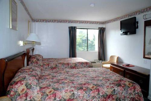 um quarto de hotel com uma cama e uma janela em Home Style Inn em Manassas