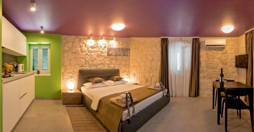 a bedroom with a bed and a table and a kitchen at Annie's stone Studio & Room in Split