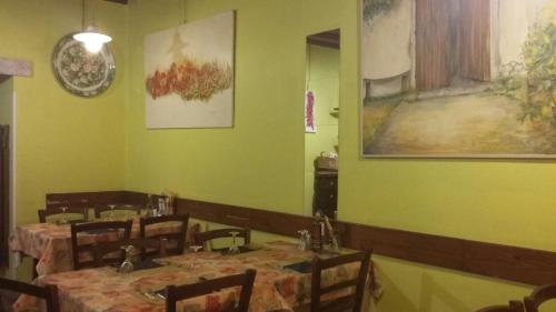 a restaurant with tables and chairs in a room with green walls at Ristorante Pizzeria al Mondo in Valstagna