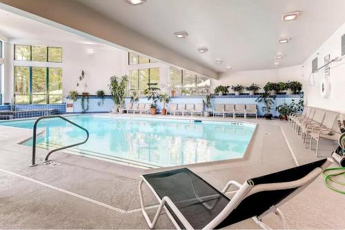 a large swimming pool in a large room with chairs at Ski In/Out Trailside Townhome in Killington