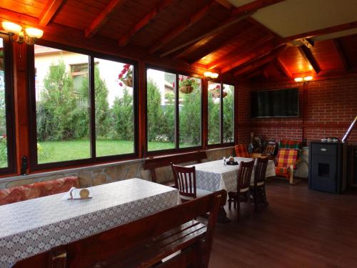 a restaurant with two tables and chairs and windows at Guest House Ivel in Sapareva Banya