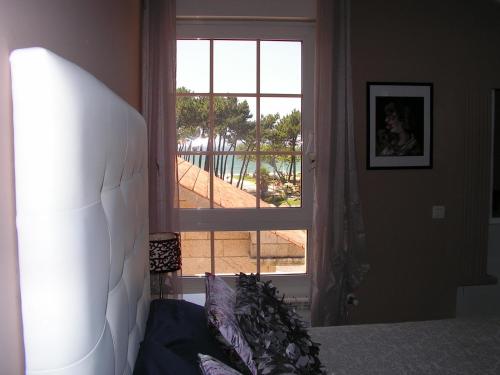 ビーゴにあるÁtico en Vigo playa Samilのベッドルーム1室(プールの景色を望む窓付)