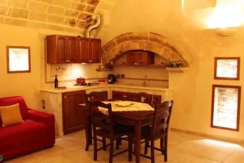 cocina con mesa y sofá rojo en Casetta Donnolo, en Oria