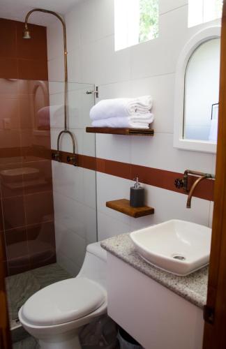 a bathroom with a toilet and a sink at Rukka Lodge in Tumbaco