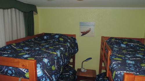 a bedroom with two twin beds and a lamp at Departamento Puerto Velero in Puerto Velero