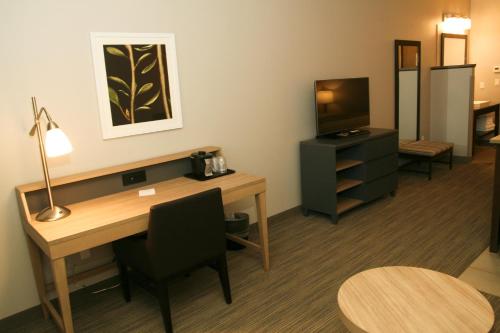 a hotel room with a desk and a television at Country Inn & Suites by Radisson, Prineville, OR in Prineville
