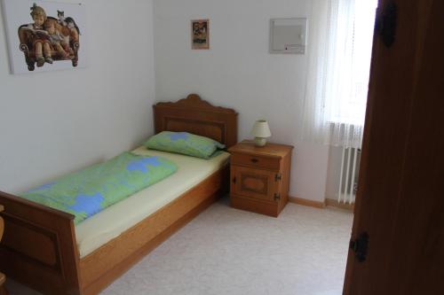 a small bedroom with a bed and a night stand at Gasthaus Mösle in Reute