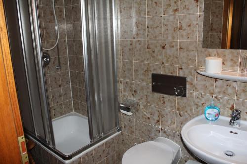 a bathroom with a shower and a toilet and a sink at Gasthaus Mösle in Reute