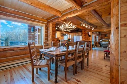 uma sala de jantar com uma mesa de madeira e cadeiras em JHRL - Macker's Cabin, Amazing Log Cabin, Sleeps 16 em Wilson