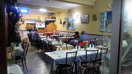 プライア・デ・ミラにあるGuestHouse O Cucoのレストランの席に座る人々