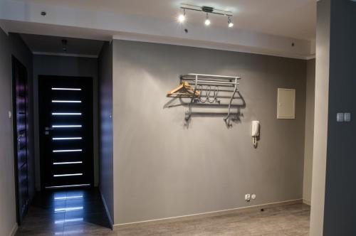 a hallway with a black door and a hanger on a wall at Apartamenty Centrum in Koszalin
