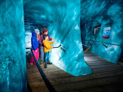 a group of people standing inside of an ice cave at Apart- Chalet GletscherGlück in Telfes im Stubai