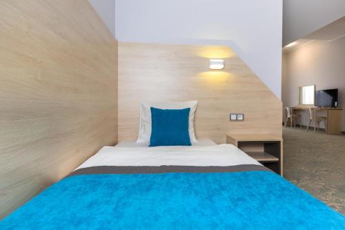 a bedroom with a bed with a blue pillow at Hotel Vela in Tczew