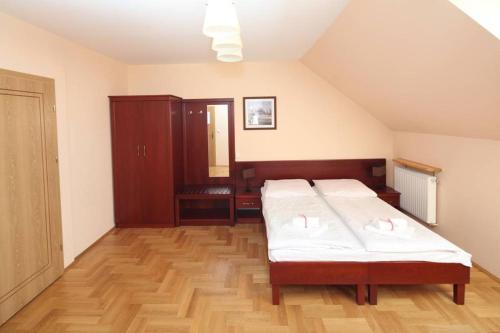 a bedroom with two beds and a wooden floor at Willa Nova in Wisła