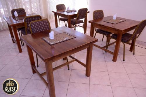 a dining room with wooden tables and chairs at The Palace Guest House in Harare