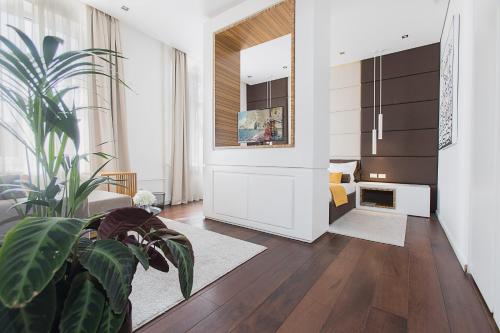 ein Wohnzimmer mit einer Topfpflanze und ein Schlafzimmer in der Unterkunft Dominic Smart & Luxury Suites - Terazije in Belgrad