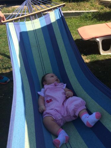 a baby is laying in a hammock at Cabana 7 Brazi in Poiana Mărului