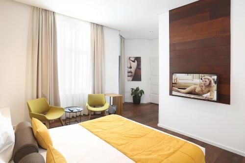 a hotel room with a bed and a tv on a wall at Dominic Smart & Luxury Suites - Terazije in Belgrade