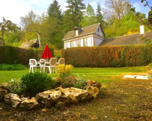 a garden with chairs and a table and a building at L'Ajoussienne in Ajou