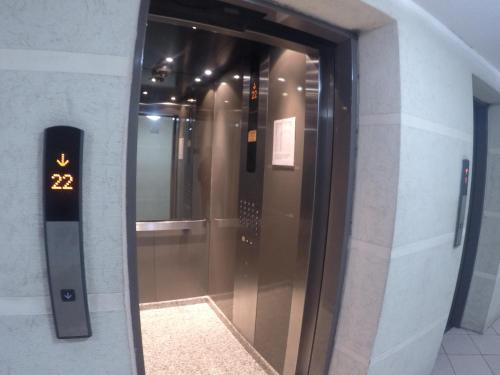 an elevator in a building with a glass door at America Departamentos in Santiago