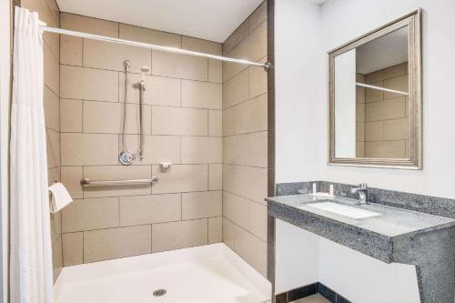 a bathroom with a sink and a shower at Days Inn by Wyndham Watertown Fort Drum in Evans Mills