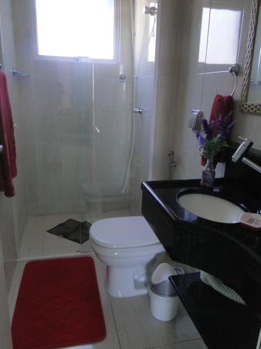 a bathroom with a toilet and a sink and a shower at Pousada Praia da Villa in Imbituba