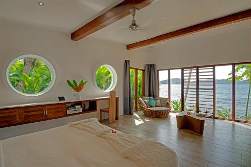 a bedroom with a large bed with a view of the ocean at The Remote Resort in Nawi