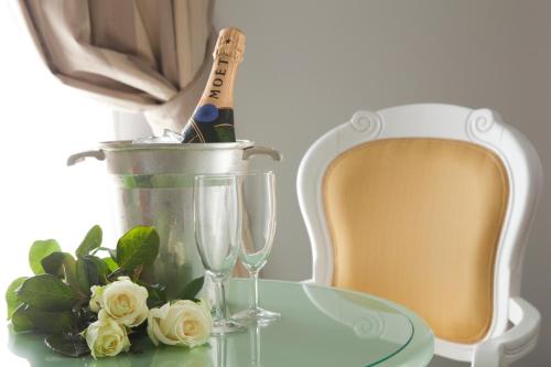 a table with a bottle of champagne and two glasses at Hotel Terme Venezia in Abano Terme