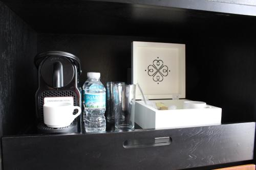 a shelf with a bottle of water a coffee maker and a box at Hotel Love It Consulado in Guadalajara